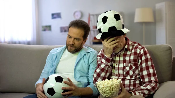 テレビでサッカーの試合を見ている不安な成人男性 チームの負けに不満 — ストック写真