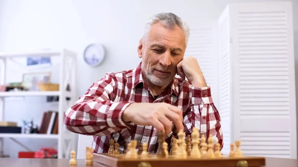 快乐的老人独自下棋 训练国际象棋比赛 — 图库照片
