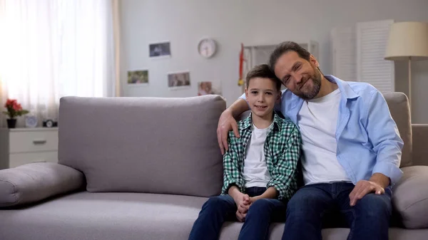 Feliz Padre Sonriente Hijo Colegial Sentado Sofá Mirando Cámara Familia — Foto de Stock