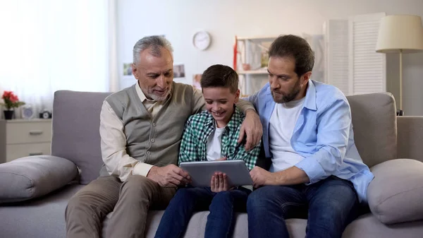 Lächelnde Männliche Familienmitglieder Die Tablette Scrollen Und Lustige Videos Ansehen — Stockfoto