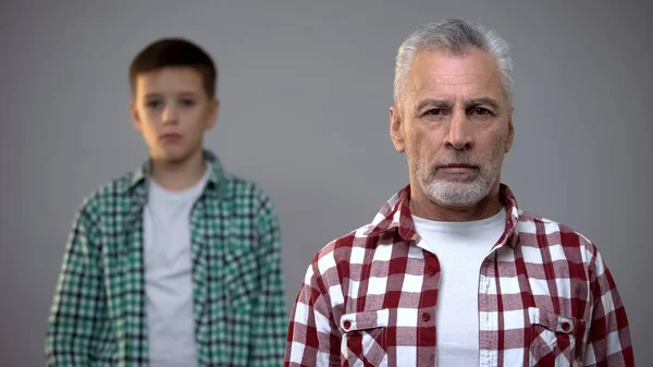 老年男性看相机 小男孩站在后面 退休年龄增加 — 图库照片