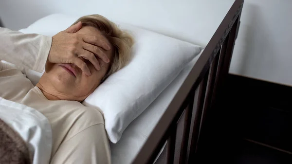 Nemocná Žena Důchodu Ležící Ošetřené Posteli Rukou Obličeji Zdravotní Péče — Stock fotografie