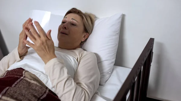 Отчаянная Больная Женщина Лежит Больничной Койке Смотрит Семейное Фото Плачет — стоковое фото