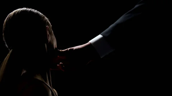 男性手触摸年轻女性的脸在黑暗的背景 人口贩运 — 图库照片