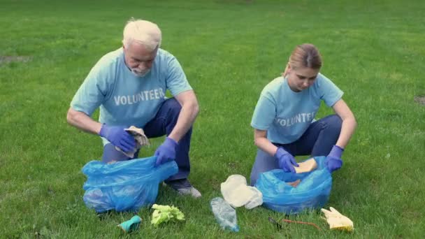 Kıdemli adam ve kızı temizlik parkı, yüksek beş veren çöp torbası toplama — Stok video