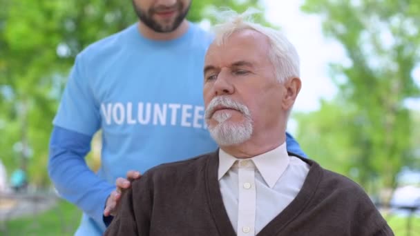 Voluntario masculino sonriendo a pensionista senior, apoyo al trabajador social, caridad — Vídeo de stock