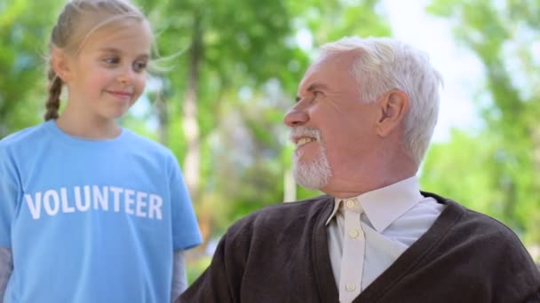 Heureux enfant volontaire étreignant pensionné mâle souriant les uns les autres, soins aux personnes âgées — Video