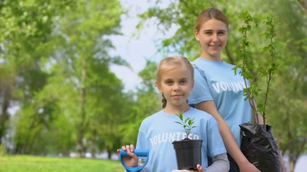 Petite fille et jeune femme tenant des jeunes arbres, projet d'éco bénévolat — Video