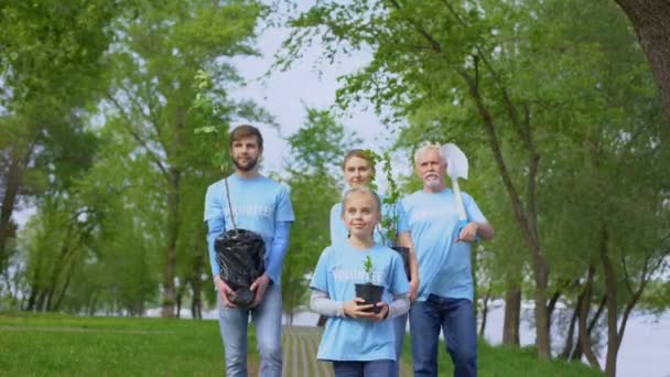 Eco voluntários caminhando parque segurando planta brotos pá, conservação da natureza — Vídeo de Stock