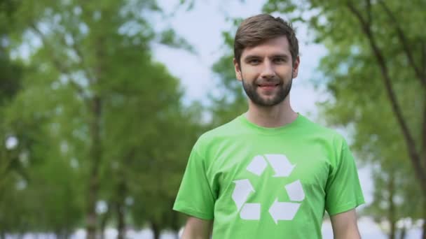 Mladý environmentálním aktivista ukazujícími v recyklačním symbolu tričko, segregace — Stock video