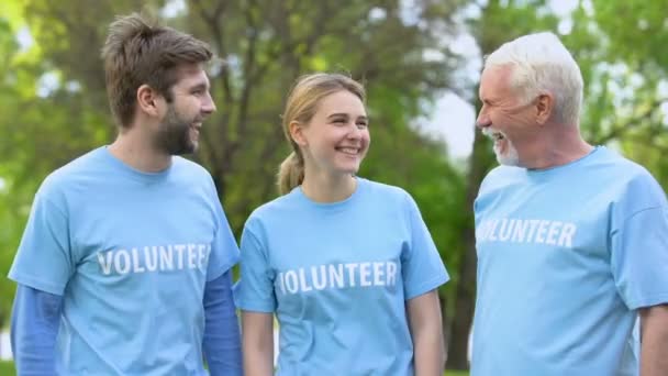 Gönüllü t-shirt sarılma üç neşeli aktivistler, eko proje başarı — Stok video