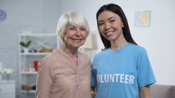 행복한 노인 여성과 여성 자원 봉사자 카메라에 미소, 노인 지원 — 비디오