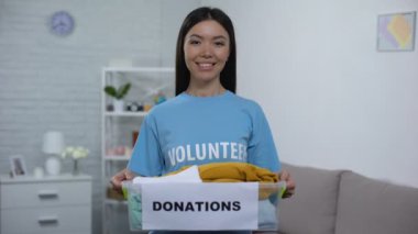 Neşeli sosyal aktivist giysi ile bağış kutusu tutan, sosyal gönüllülük