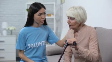 Bakım sosyal aktivist baston ile üzgün yaşlı kadın rahatlatıcı, destek