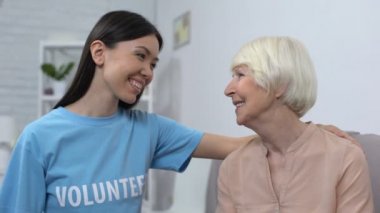 Olgun kadına sarılan kadın aktivist birbirlerine gülümsüyor, sosyal gönüllülük