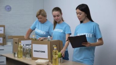 Sosyal merkez çalışanları gıda bağış kutuları hazırlama notları yapma, gönüllü