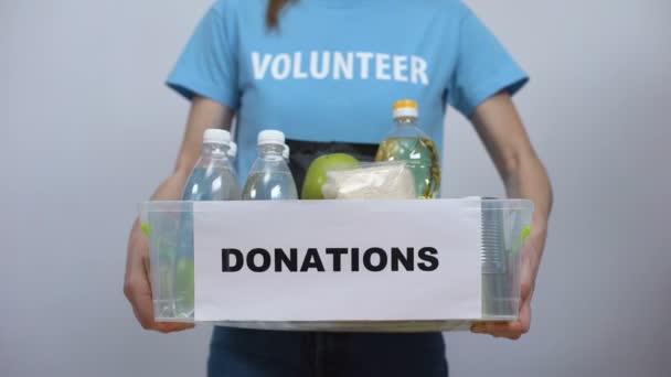 Manos poniendo caja de donación de personal de alimentos, evento benéfico de proyecto de voluntariado — Vídeo de stock