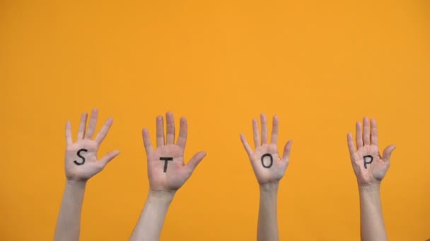 Zastavit psané dlaně na oranžovém pozadí, varování nebezpečí, protestní výraz — Stock video