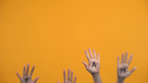 チームはオレンジ色の背景に手のひらを書いた, 団結協力, グループの一体性 — ストック動画