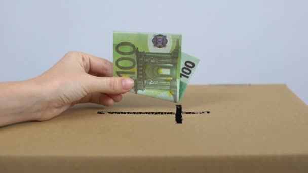 Женская рука кладет банкноту евро в коробку для пожертвований церкви, благотворительный фонд — стоковое видео