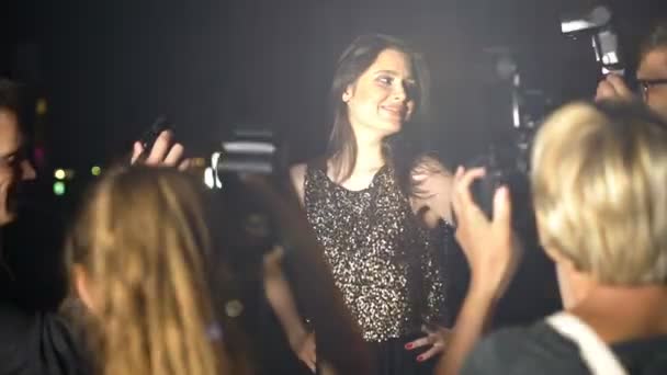 Famous woman in shiny dress posing in front of paparazzi cameras, evening party — Stock Video