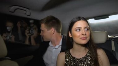 Gülümseyen yıldız çift arabadan paparazzi bakarak, şöhret ve zafer zevk