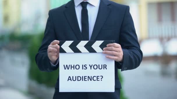 男性有名人の手でクラッパーボード上のあなたの聴衆の質問は誰ですか、 pr — ストック動画