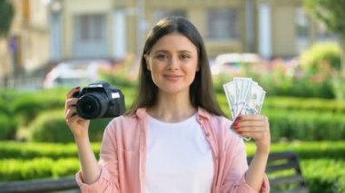 Sevimli kadın kamera ve kamera, karlı meslek dolar demet gösteren