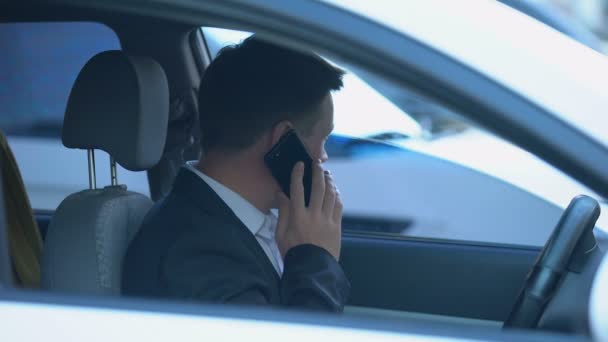 Agente secreto espiando desde el coche, hablando por teléfono con su pareja, discutiendo información — Vídeos de Stock