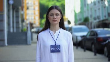 Mikrofon ve basın rozeti ile kamera, Tv bakarak ciddi kadın gazeteci