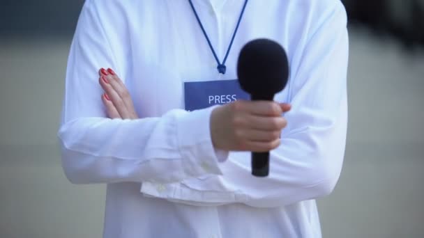 Женщина с микрофоном и значком аккредитации для прессы, пропуск для журналистов — стоковое видео