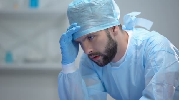 Chockad kirurg funderar på sista misslyckade operationen, ansvarsfullt arbete — Stockvideo