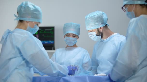 Equipe de cirurgiões e assistentes que realizam operação hospitalar invasiva, saúde — Vídeo de Stock