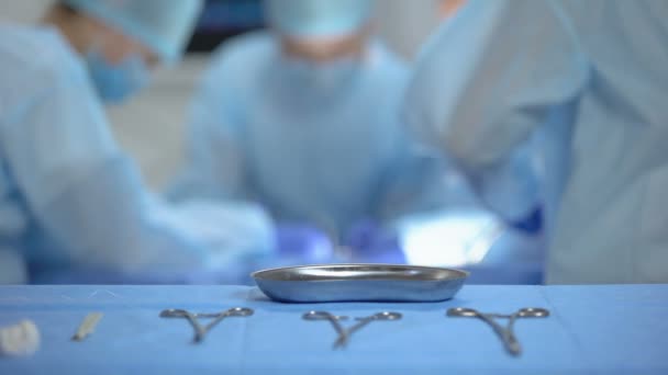 Enfermeira colocando algodão sangrento usado em bandeja médica estéril, cirurgia hospitalar — Vídeo de Stock
