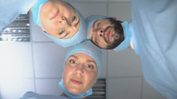 Vážný chirurgickův tým se dívá na pacienta, který se probouzí po kómatu, sleduje — Stock video