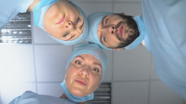 Equipo de cirujanos con máscaras, listos para la operación, paciente pov en la conciencia — Vídeo de stock