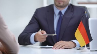 Alman konsolosluk görevlisi kadına pasaport veriyor, mülteci vizesi, sığınma durumu