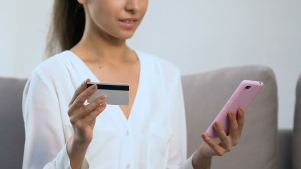 Щаслива жінка, що вставляє номер кредитної картки на мобільний телефон, додаток для покупок — стокове відео