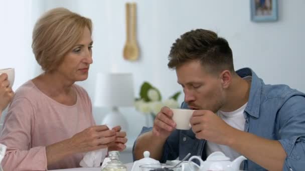 Caring mother wiping lips of son during lunch with girlfriend, shocked situation — Stock Video