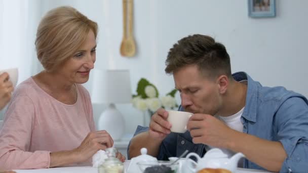 Young woman shocked watching her future mother-in-law wiping lips to son — Stock Video