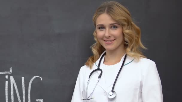 Женщина-врач со стетоскопом улыбается, медицинское волонтерство, благотворительная организация — стоковое видео