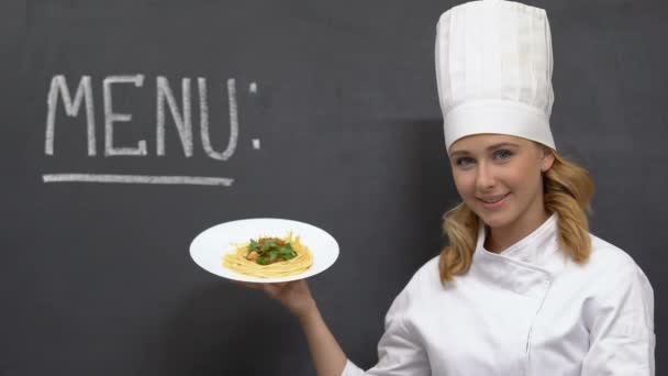 Bela cozinheira demonstrando saborosa massa no prato, cozinha italiana, comida — Vídeo de Stock