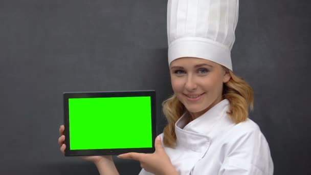 Senhora em uniforme de cozinheiro mostrando guia prekeyed, propondo receitas nutricionais saudáveis — Vídeo de Stock
