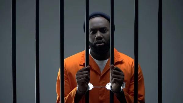 Unhappy black prisoner showing handcuffs, innocent male waiting for justice — Stock Photo, Image