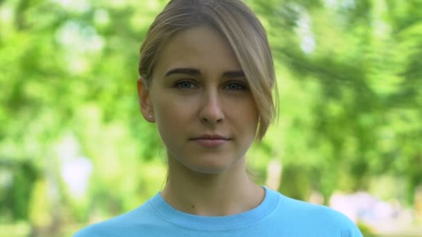 Jeune femme souriant à la caméra, debout dans le parc, volontariat environnemental — Video