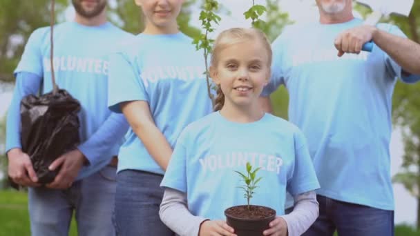 Miembros de la familia feliz sostienen árboles plantados y pala, preservación del medio ambiente — Vídeo de stock