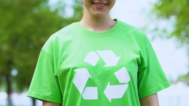Miła Kobieta w zielonej koszulce z symbolem recyklingu, wolontariat środowiskowy — Wideo stockowe
