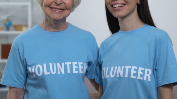 Пожилые и молодые женщины-волонтеры, ищущие камеру и улыбающуюся благотворительную организацию — стоковое видео