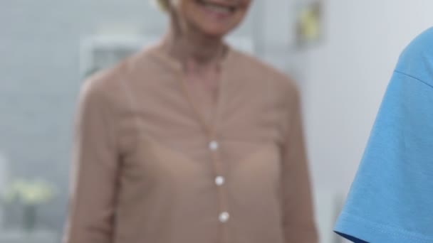 Женщина-волонтер обнимает улыбающуюся пожилую женщину в доме престарелых, заботится и поддерживает — стоковое видео