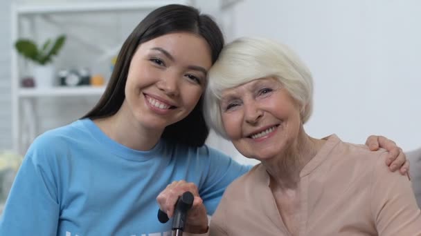 Ευτυχισμένοι νέοι και συνταξιούχοι κυρίες που κοιτάζουν την κάμερα, αγκαλιάζοντας και χαμογελώντας, υποστήριξη — Αρχείο Βίντεο